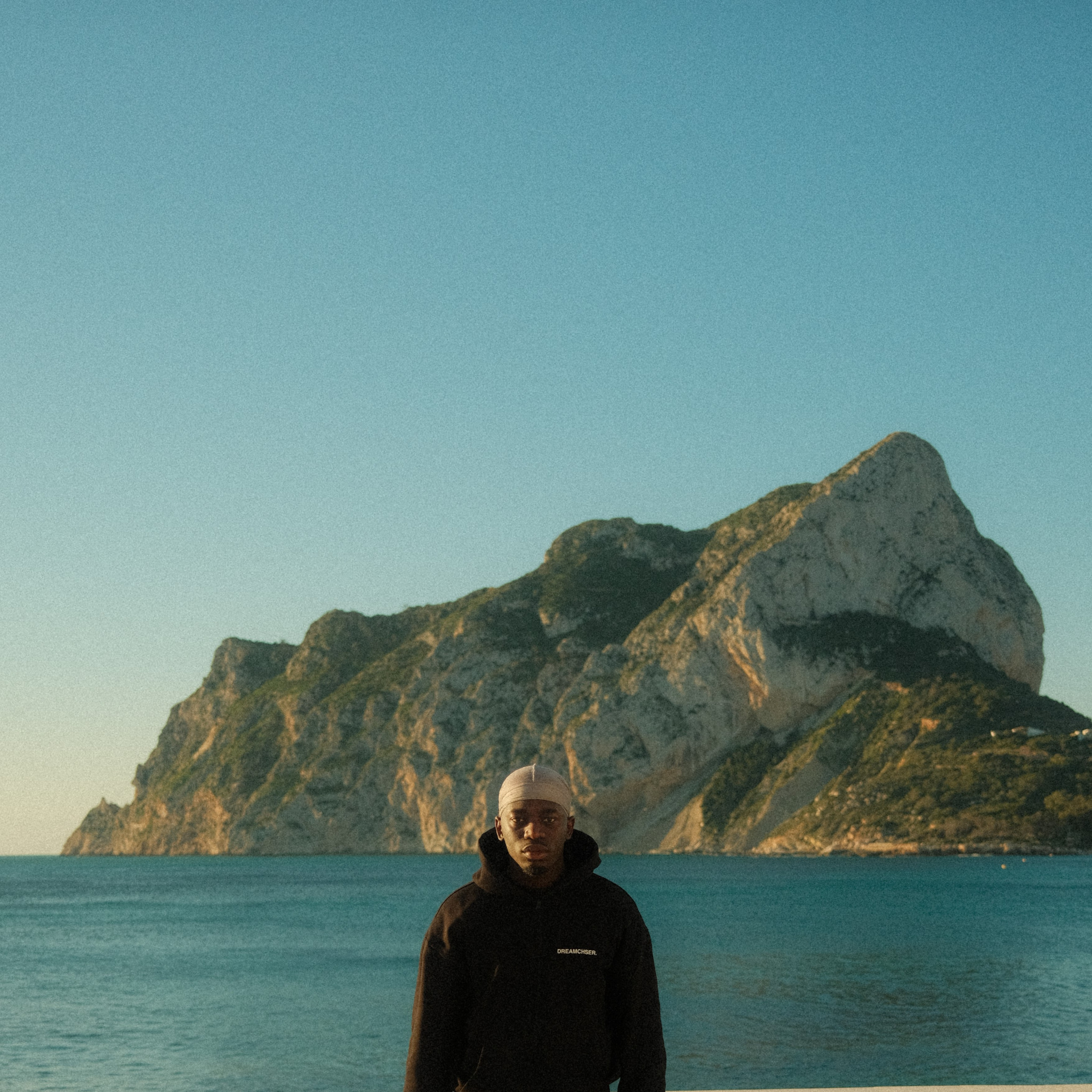 Portrait by the sea beneath a mountain