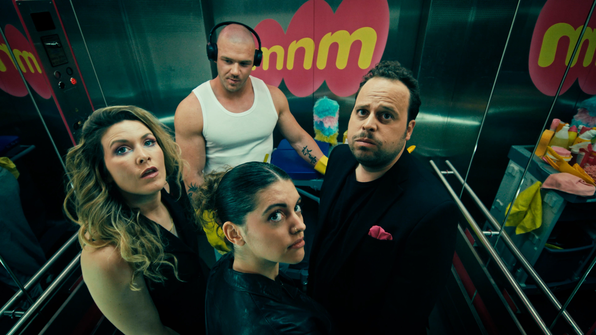 Cast gathered inside an MNM elevator
