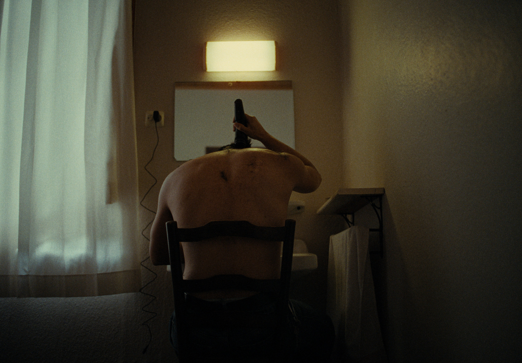 A man sitting alone in a dim room