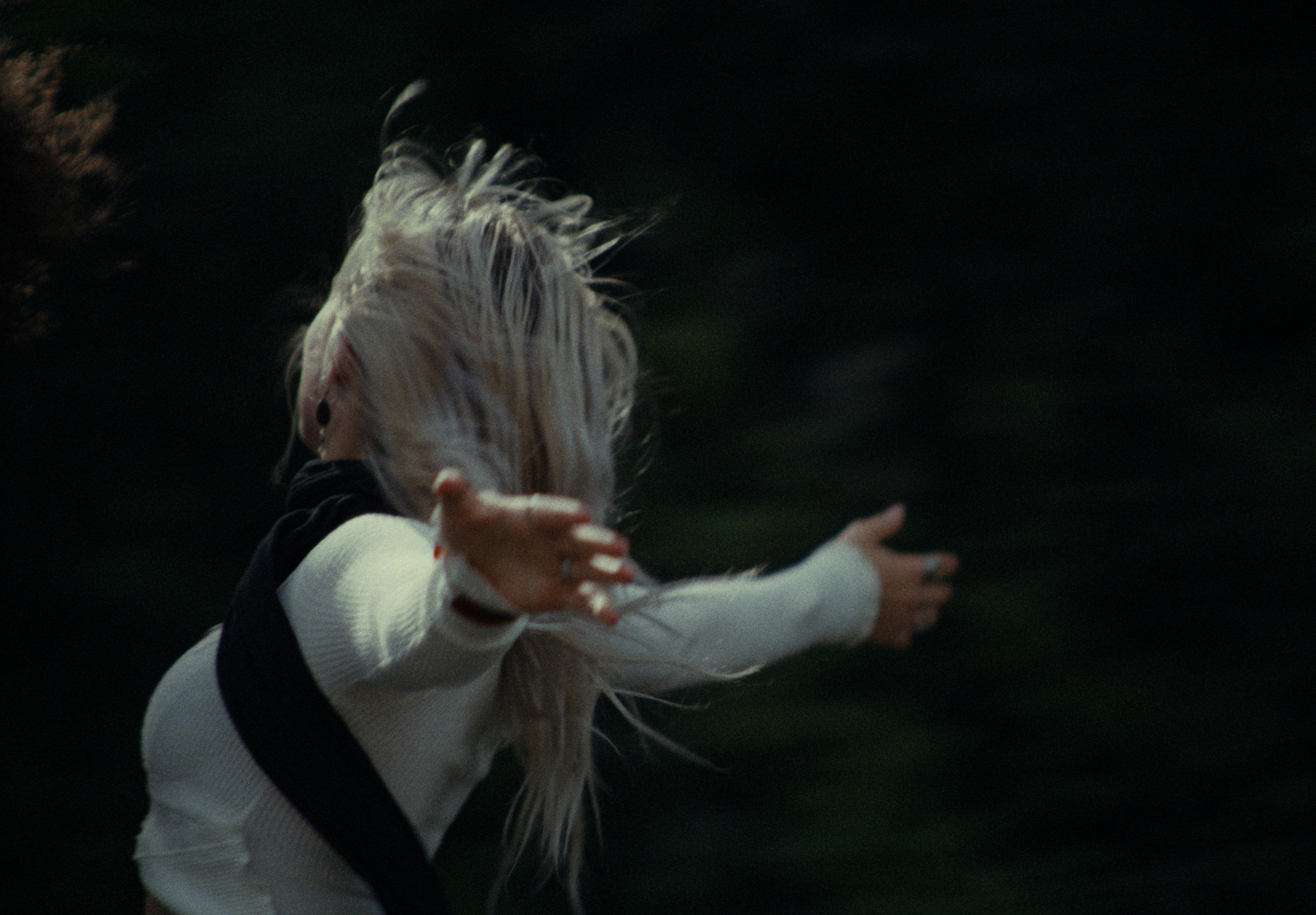 A young woman turning with her arms open