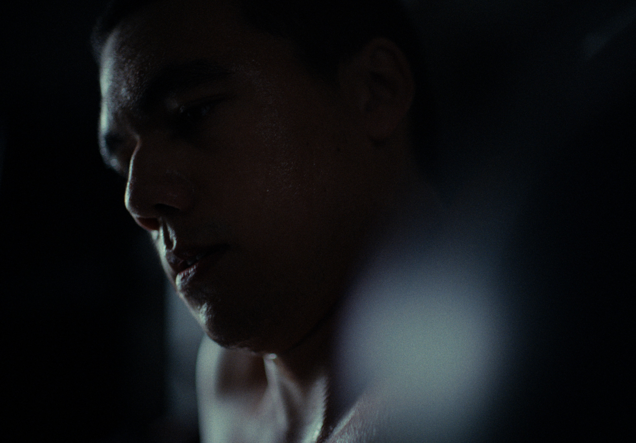 A young man emerging from shadow