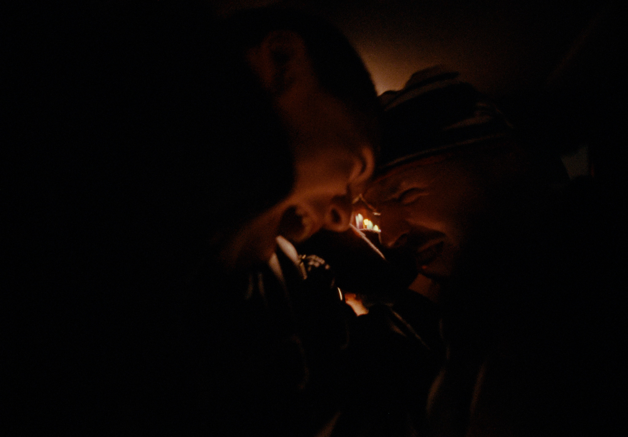 Two people sharing a light in a dark car